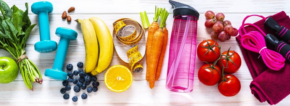 Frutas frescas, equipamentos de treino e garrafa de água — nutrição clínica e esportiva